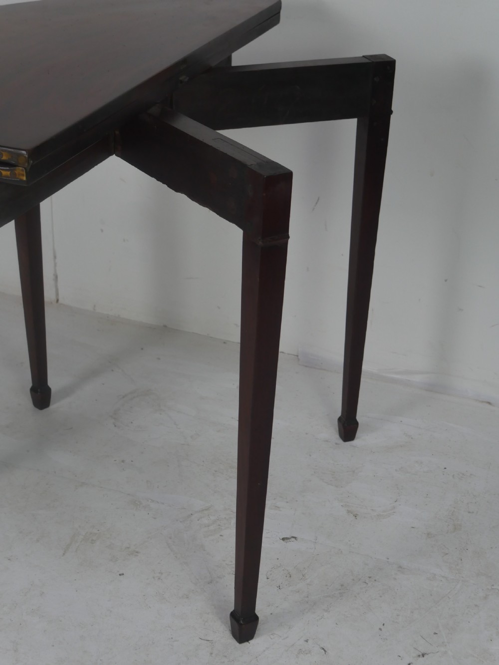 A Georgian mahogany demi-lune side table featuring a semi-circular top and four slender square tapered legs. View X