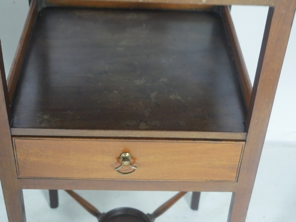 A narrow dark mahogany bedside table featuring a top surface with a gallery back, an open central shelf, a single drawer with a brass drop handle, and cross stretchers with a turned dish centre. View III