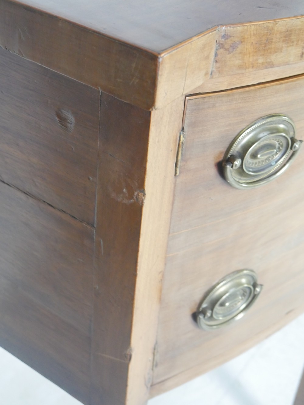A Georgian mahogany bow-front sideboard featuring a central arch aperture, multiple drawers with oval brass handles, and square tapered legs. View VIII