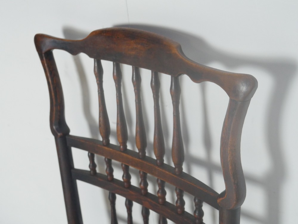 A pair of Georgian brown elm side chairs featuring spindle backrests, woven rush seats, and turned front legs. View III