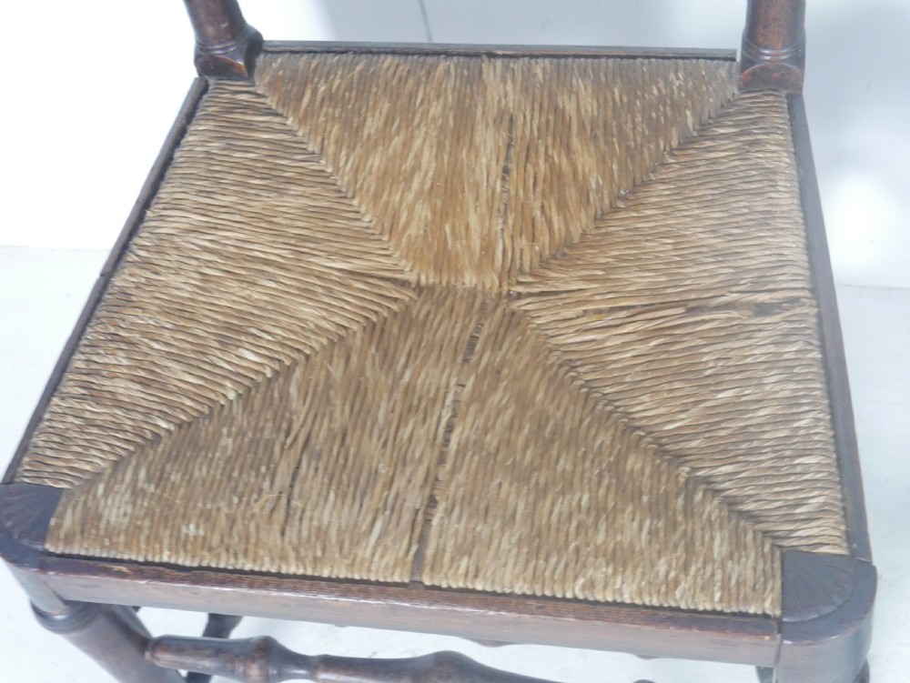 A pair of Georgian brown elm side chairs featuring spindle backrests, woven rush seats, and turned front legs. View XI