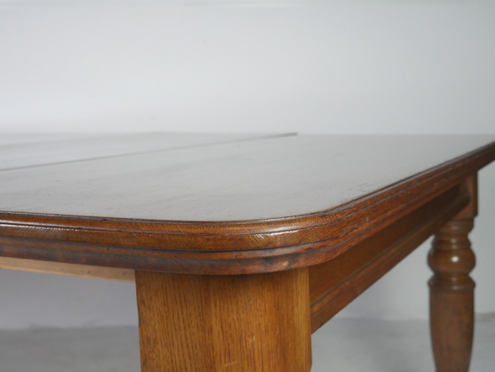 Victorian mahogany extending dining table resting on four turned legs with metal castors. View X