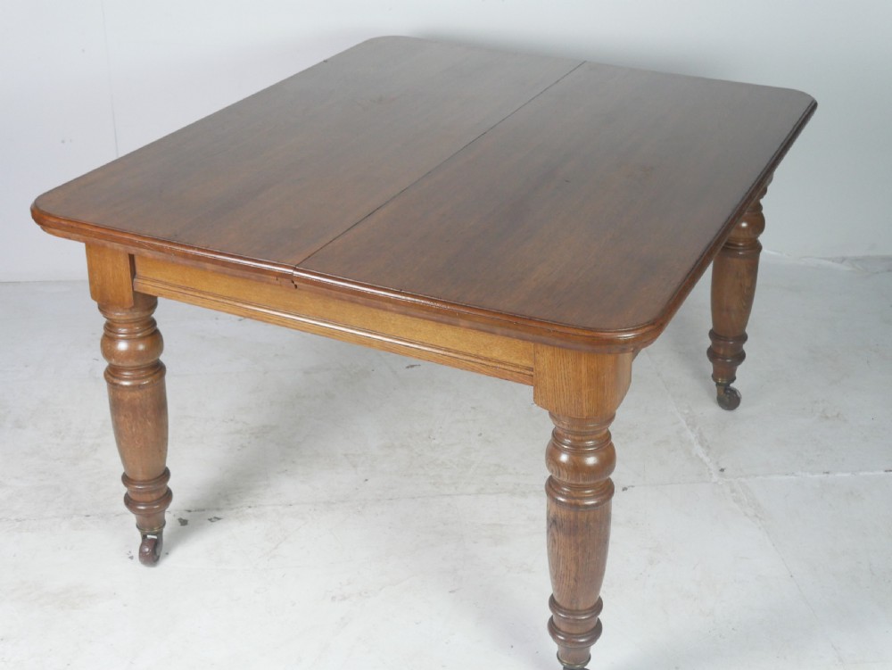 Victorian mahogany extending dining table resting on four turned legs with metal castors. View XII