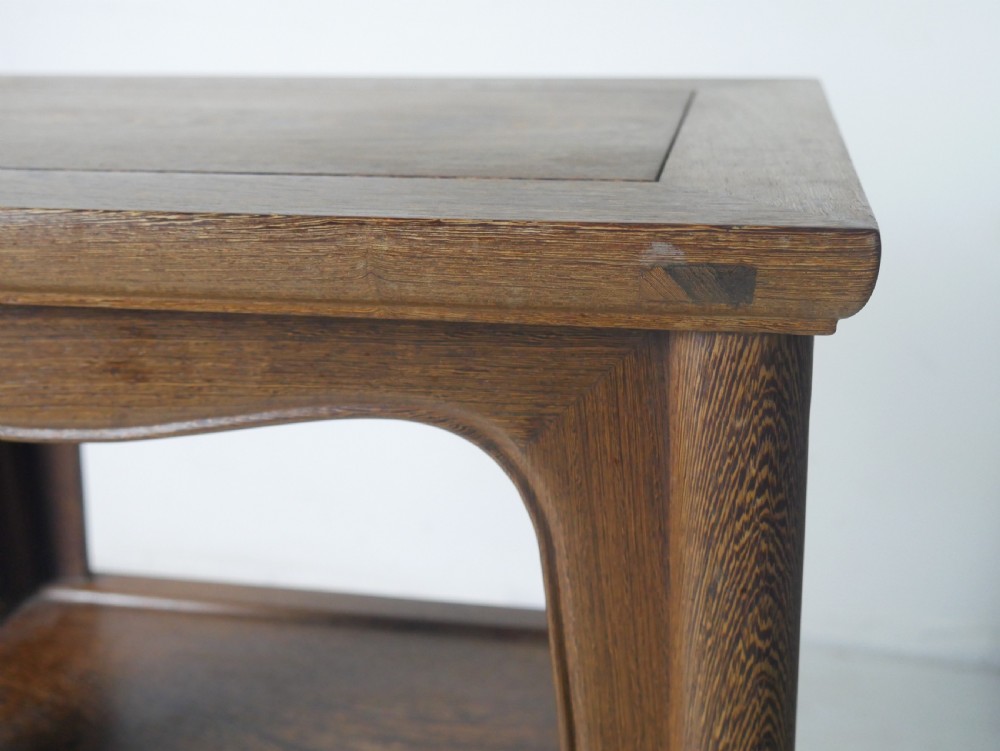 A warm brown oak side table featuring an upper rectangular top, arched aprons, a lower storage shelf, and straight legs. View III