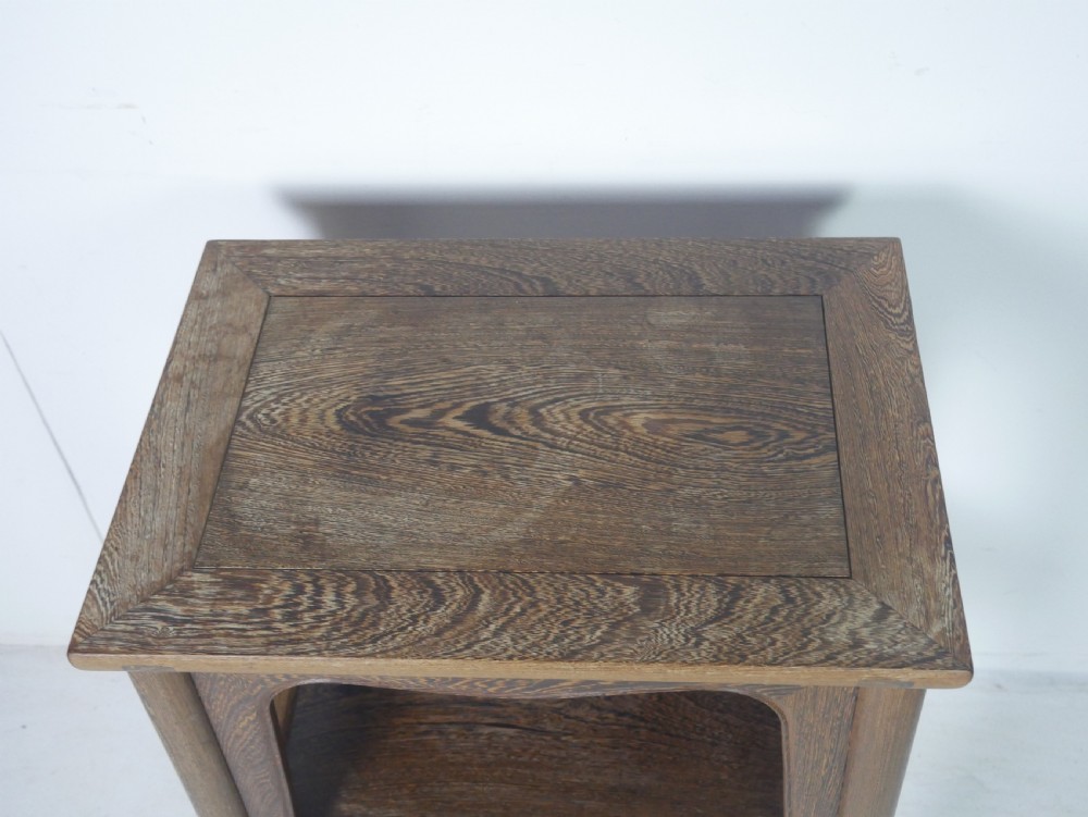 A warm brown oak side table featuring an upper rectangular top, arched aprons, a lower storage shelf, and straight legs. View V