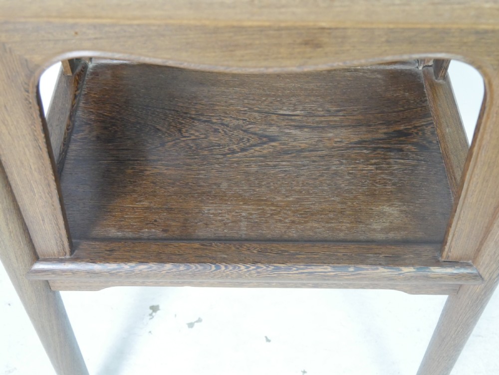 A warm brown oak side table featuring an upper rectangular top, arched aprons, a lower storage shelf, and straight legs. View IX