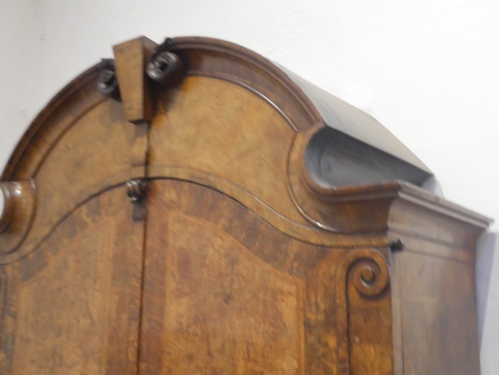 An 18th-century Dutch Rococo burr walnut cabinet featuring an arched moulded cornice, panelled doors, and a bombe three-drawer base with brass hardware. View VIII