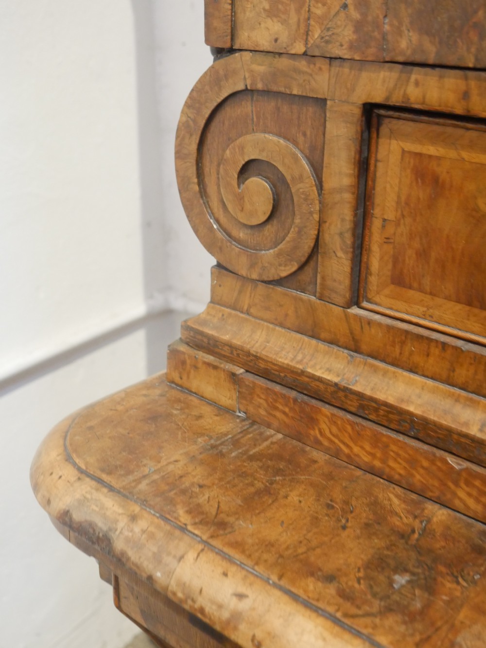 An 18th-century Dutch Rococo burr walnut cabinet featuring an arched moulded cornice, panelled doors, and a bombe three-drawer base with brass hardware. View X