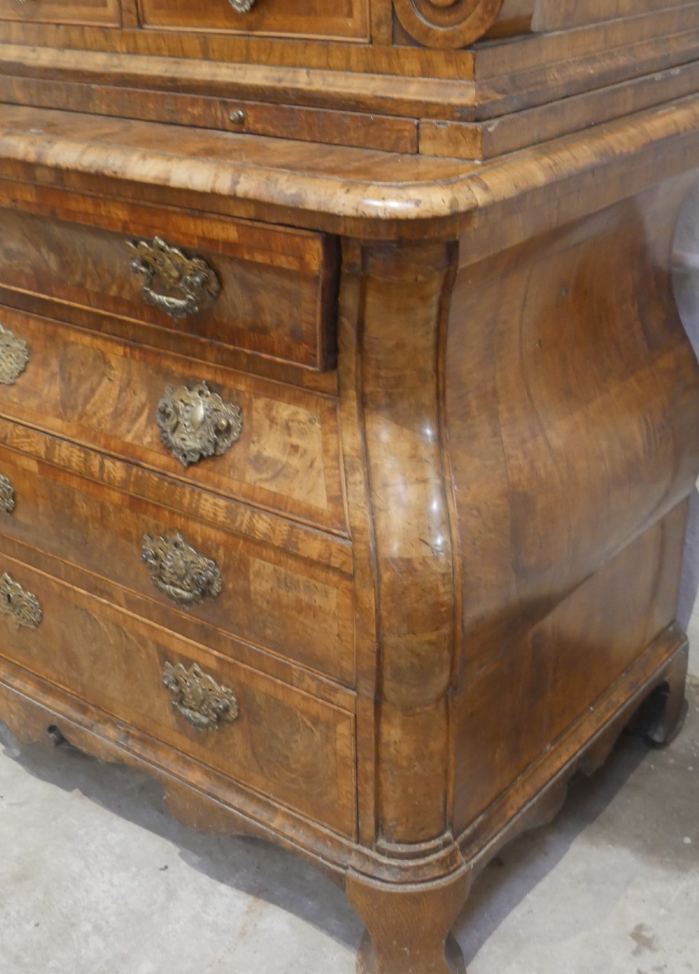An 18th-century Dutch Rococo burr walnut cabinet featuring an arched moulded cornice, panelled doors, and a bombe three-drawer base with brass hardware. View XIII