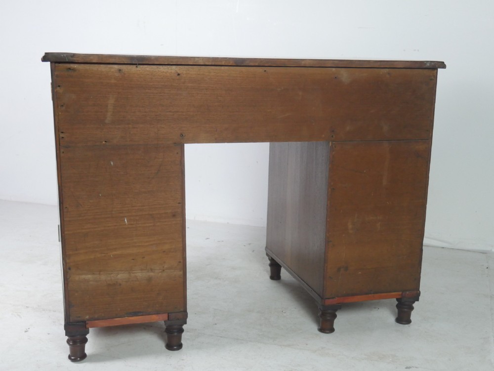 An antique mahogany kneehole dressing table featuring flame veneer drawer fronts, panelled cupboard doors, and turned feet. View VIII