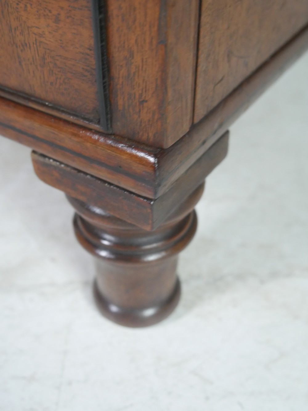 An antique mahogany kneehole dressing table featuring flame veneer drawer fronts, panelled cupboard doors, and turned feet. View IX