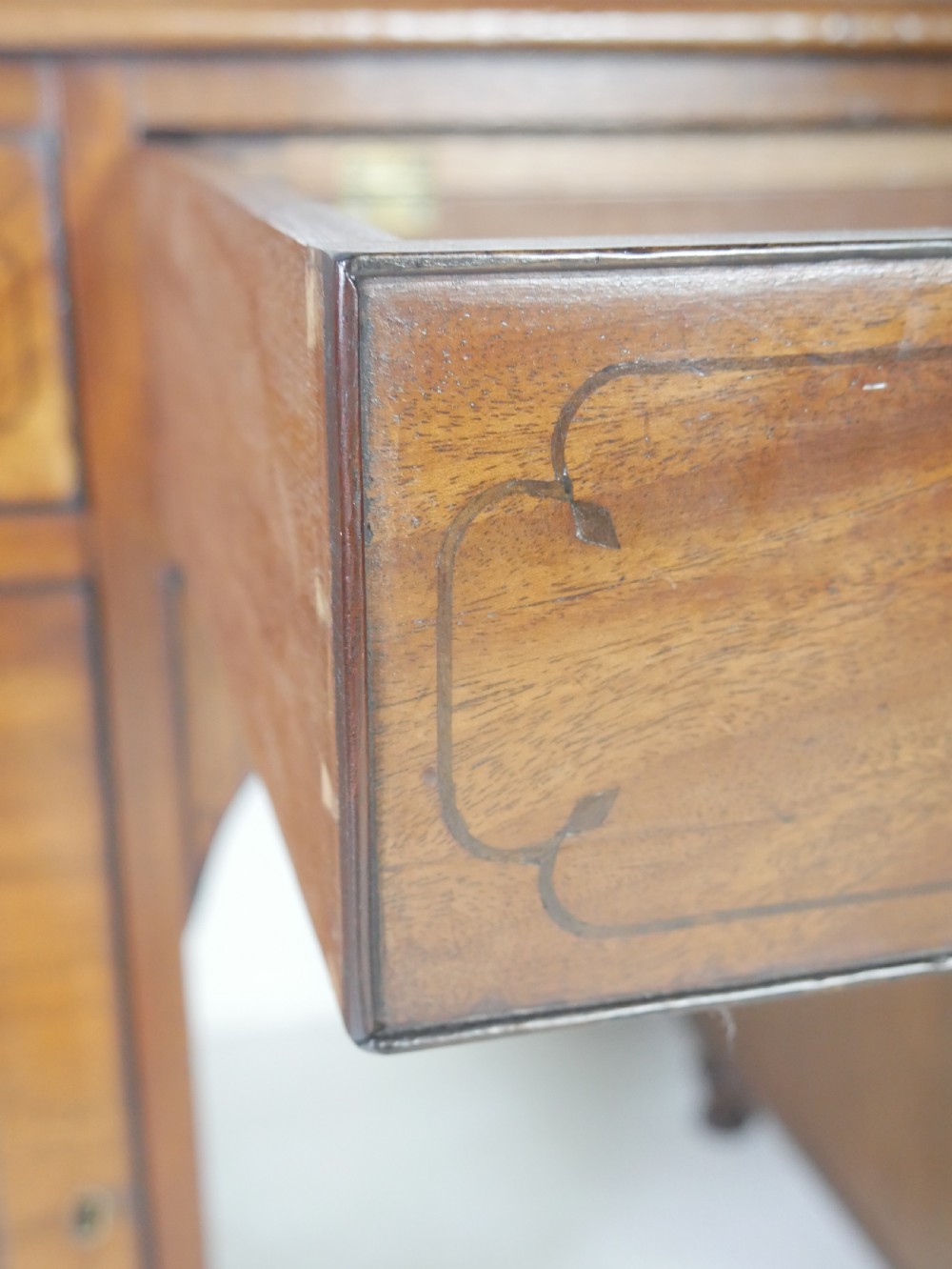 An antique mahogany kneehole dressing table featuring flame veneer drawer fronts, panelled cupboard doors, and turned feet. View XI