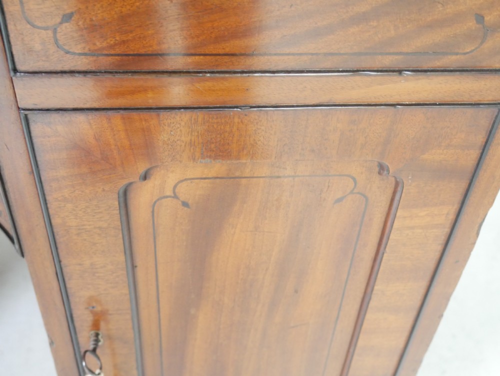 An antique mahogany kneehole dressing table featuring flame veneer drawer fronts, panelled cupboard doors, and turned feet. View XIV