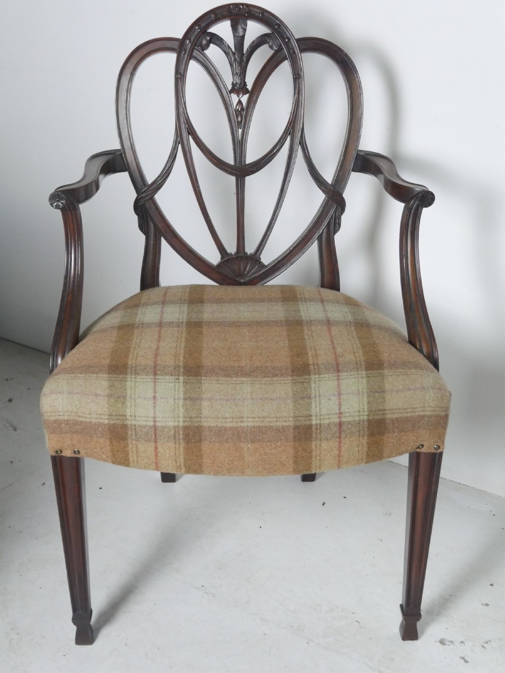A pair of Hepplewhite style dark mahogany armchairs featuring openwork shield backs and tartan upholstered seats. View II