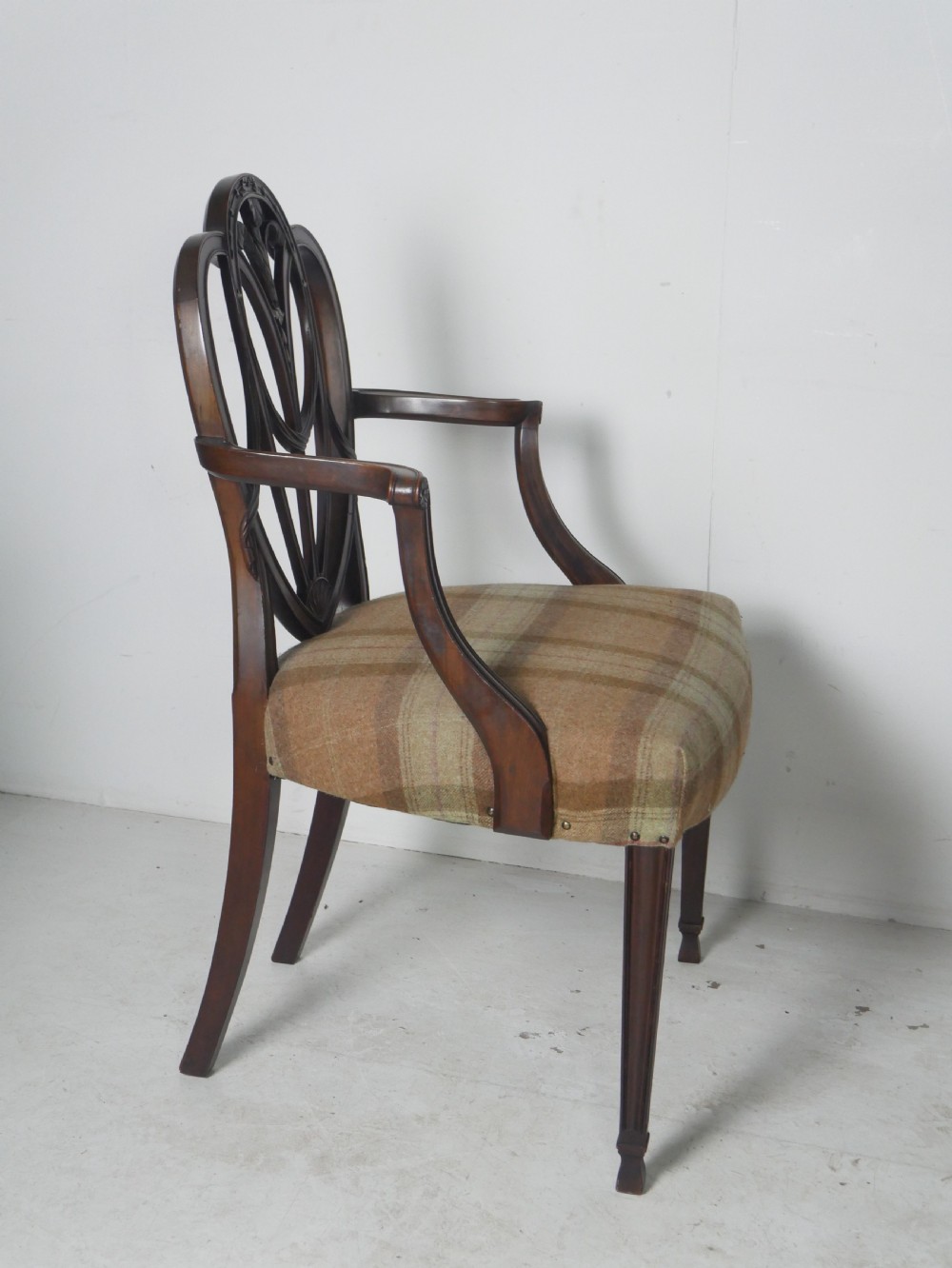 A pair of Hepplewhite style dark mahogany armchairs featuring openwork shield backs and tartan upholstered seats. View III