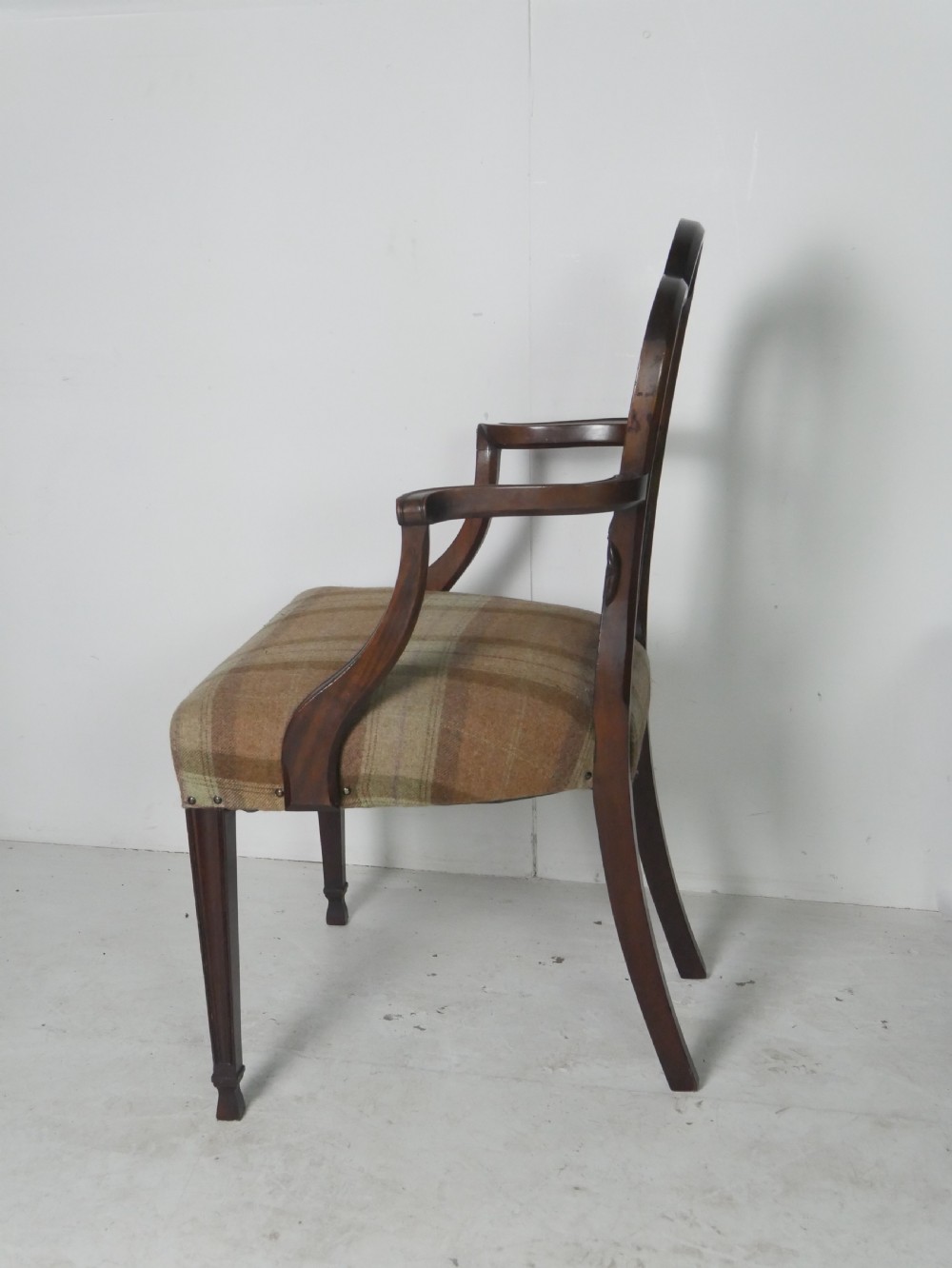 A pair of Hepplewhite style dark mahogany armchairs featuring openwork shield backs and tartan upholstered seats. View V