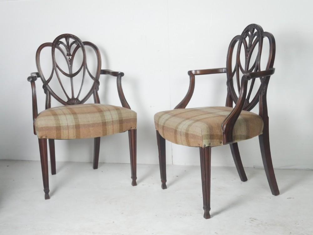 A pair of Hepplewhite style dark mahogany armchairs featuring openwork shield backs and tartan upholstered seats. View VIII