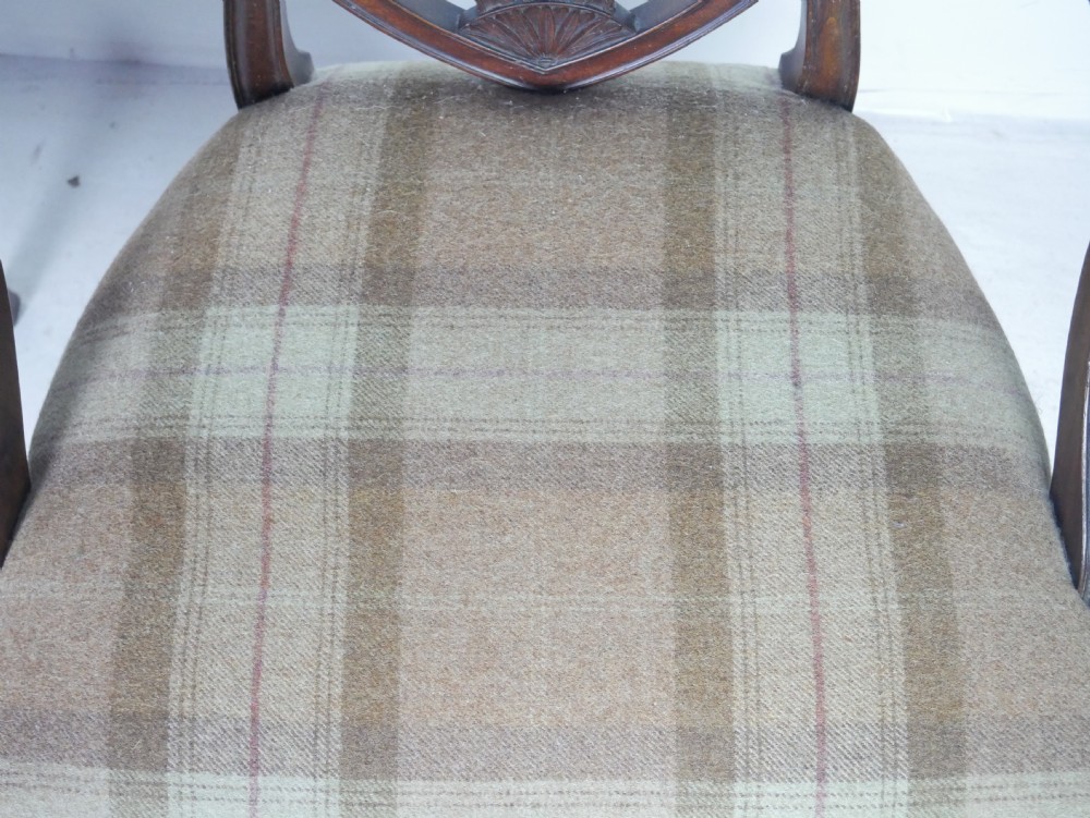 A pair of Hepplewhite style dark mahogany armchairs featuring openwork shield backs and tartan upholstered seats. View XII