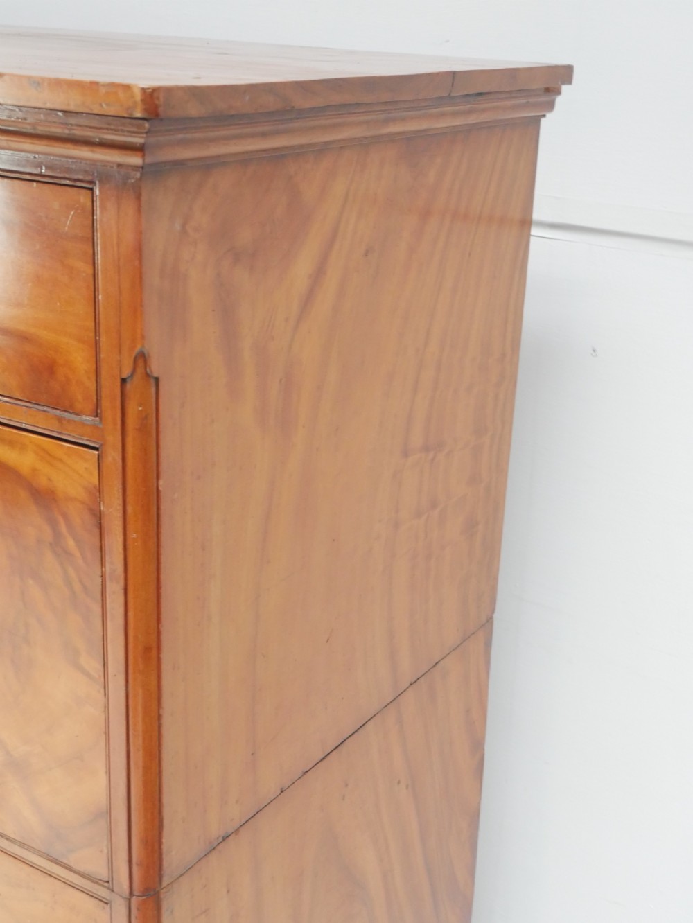 A 19th-century warm brown wooden tallboy chest featuring two short drawers over three long drawers with intricate carved foliate handles. View VIII
