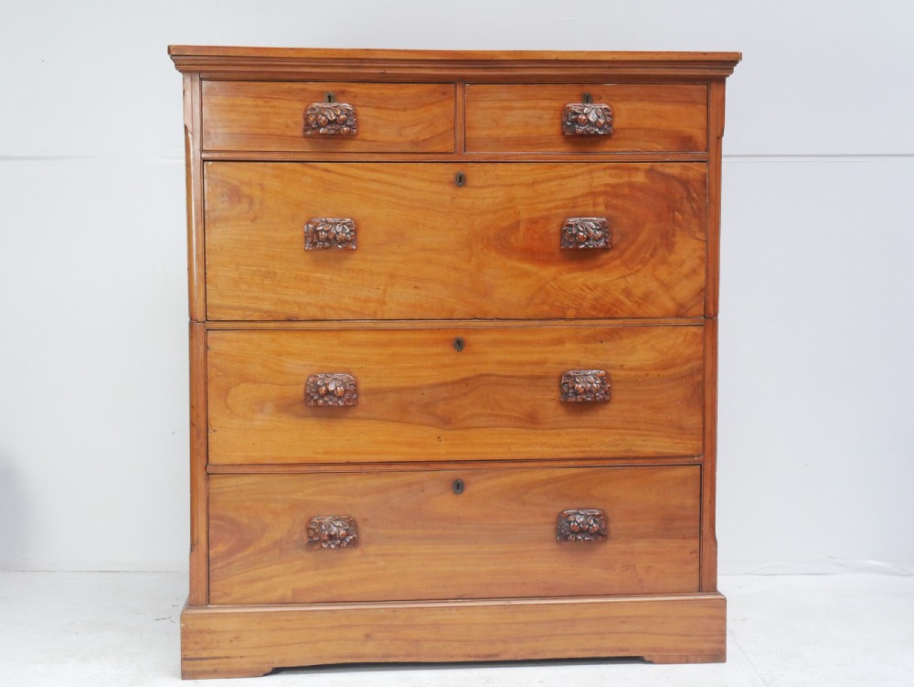 A 19th-century warm brown wooden tallboy chest featuring two short drawers over three long drawers with intricate carved foliate handles. View XVI