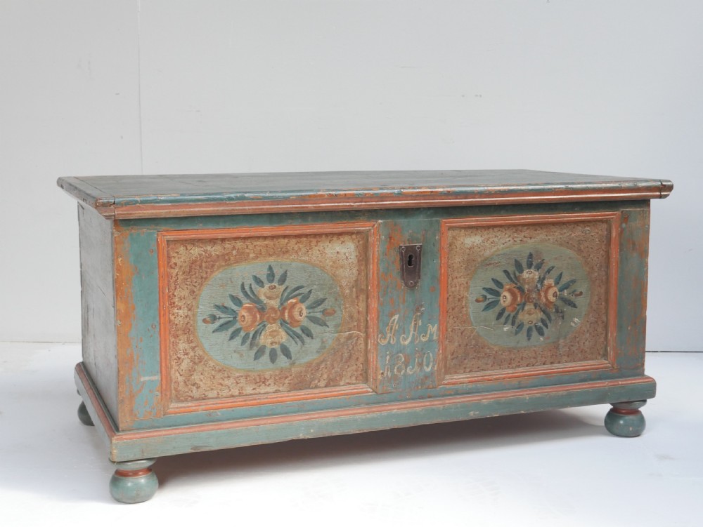 A 19th-century Swedish painted wooden coffer chest featuring green paint, oval floral medallions, moulded framing, and hand-painted initials dated 1810.