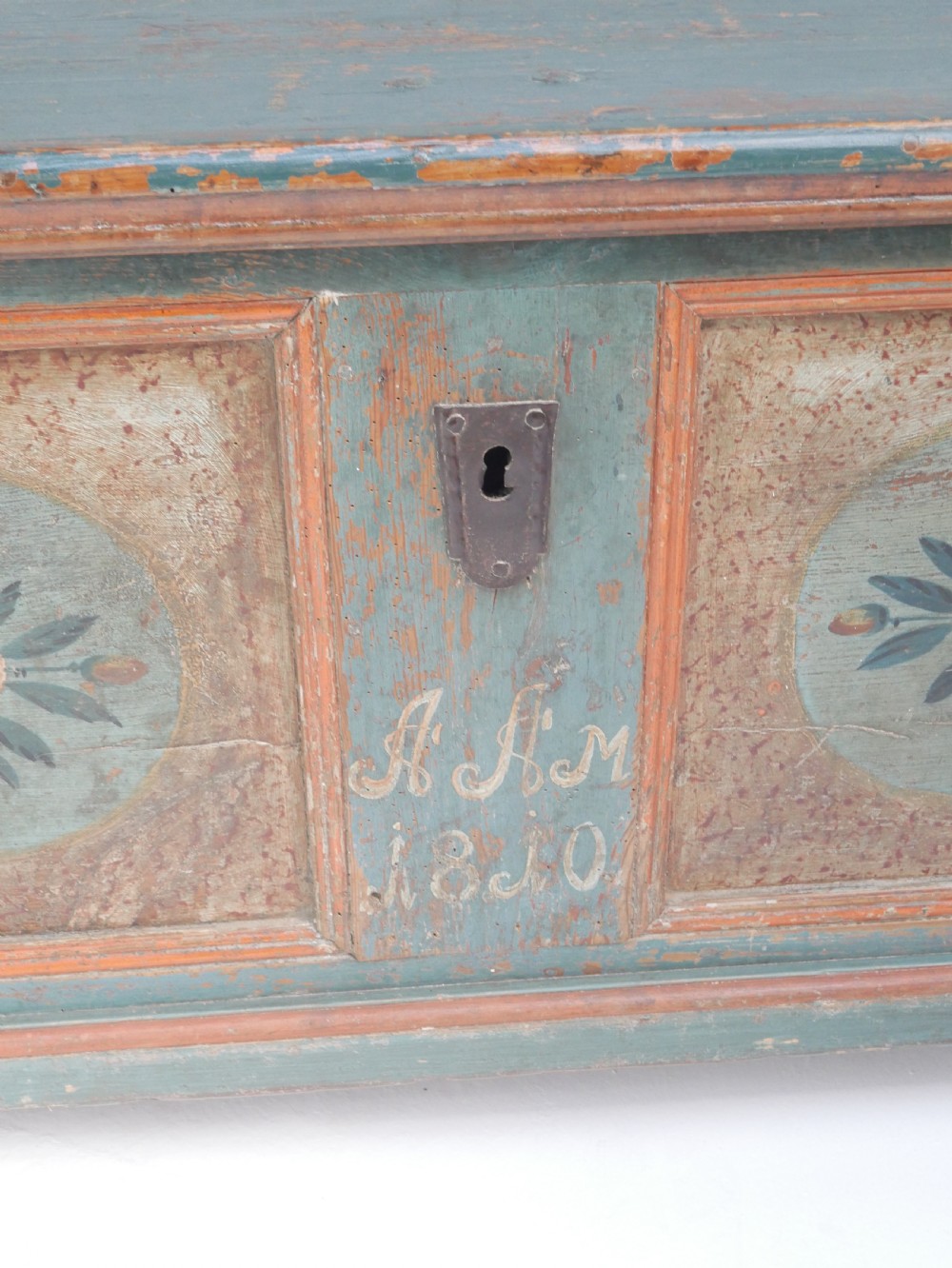 A 19th-century Swedish painted wooden coffer chest featuring green paint, oval floral medallions, moulded framing, and hand-painted initials dated 1810. View XIX