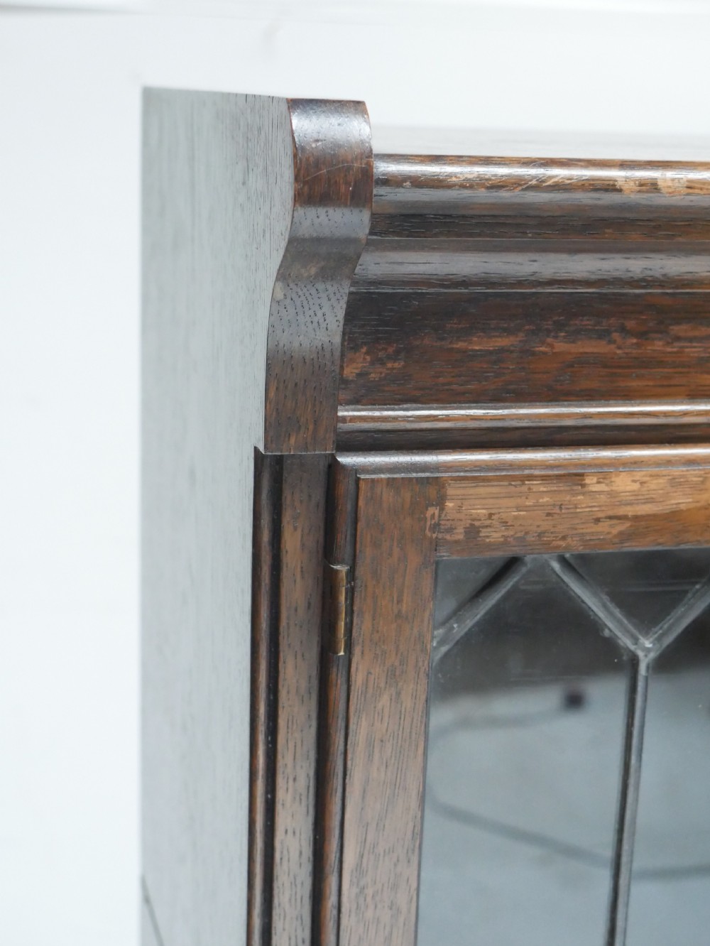 An oak stacking bookcase featuring two upper tiers with double diamond-pattern leaded glass doors above a lower cupboard with two solid panelled wooden doors. View VI