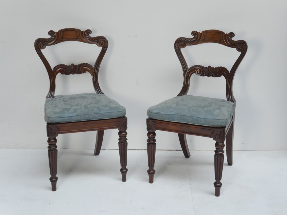 Pair of Regency mahogany side chairs with blue fabric seats and turned reeded legs.