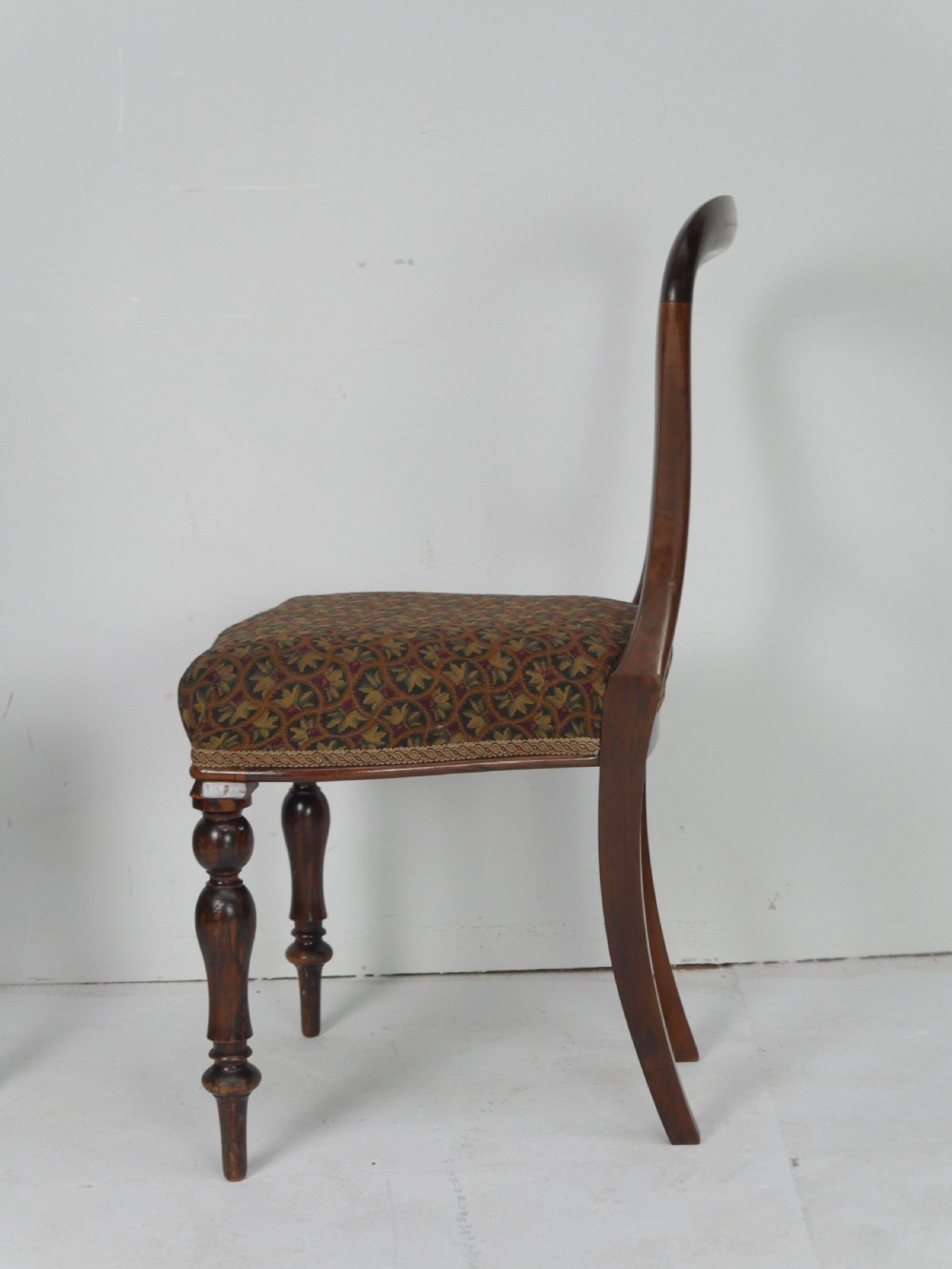 A pair of Victorian rosewood balloon back side chairs featuring turned front legs and patterned upholstered seats. View II