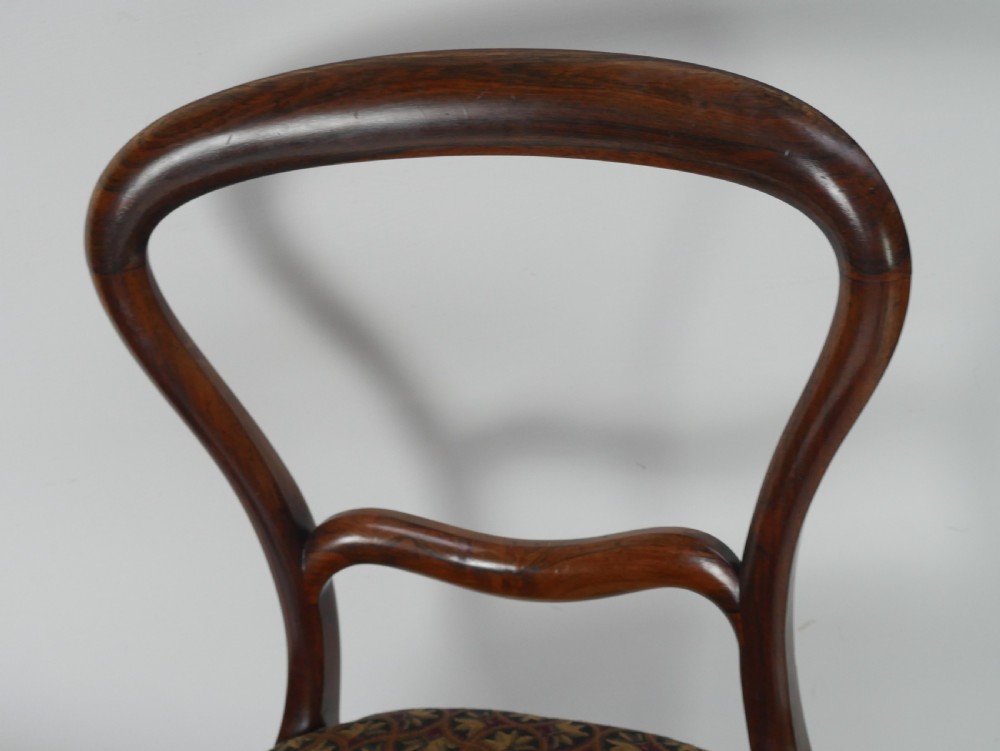 A pair of Victorian rosewood balloon back side chairs featuring turned front legs and patterned upholstered seats. View IX