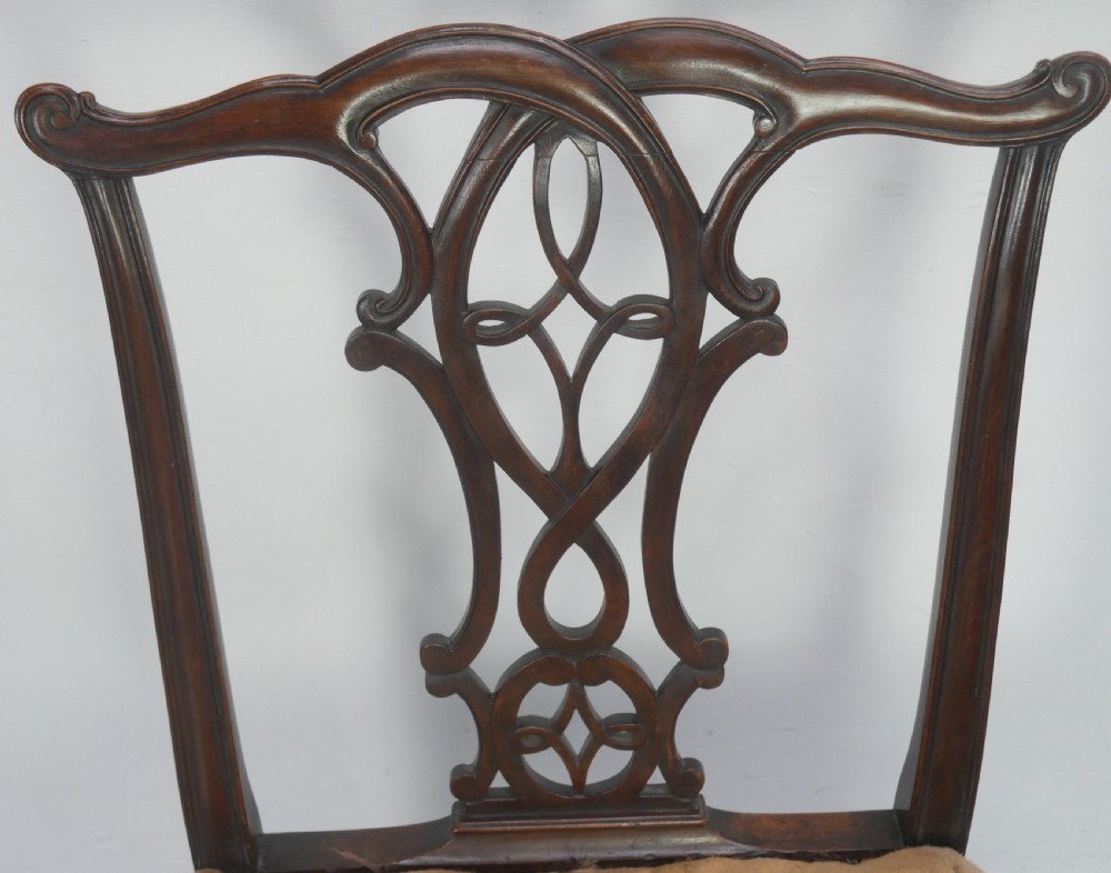 A set of eight dark mahogany Georgian style dining chairs featuring carved pierced splats and patterned fabric drop-in seats, comprising six side chairs and two carver armchairs. View III