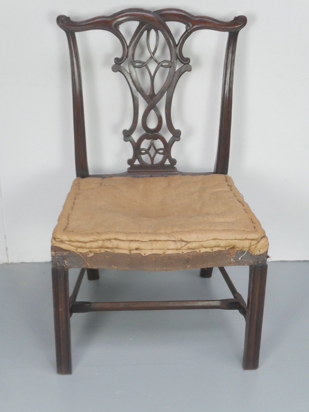 A set of eight dark mahogany Georgian style dining chairs featuring carved pierced splats and patterned fabric drop-in seats, comprising six side chairs and two carver armchairs. View IV