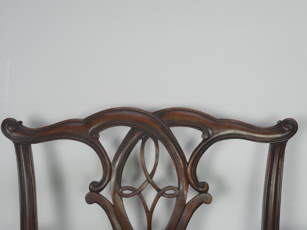 A set of eight dark mahogany Georgian style dining chairs featuring carved pierced splats and patterned fabric drop-in seats, comprising six side chairs and two carver armchairs. View V