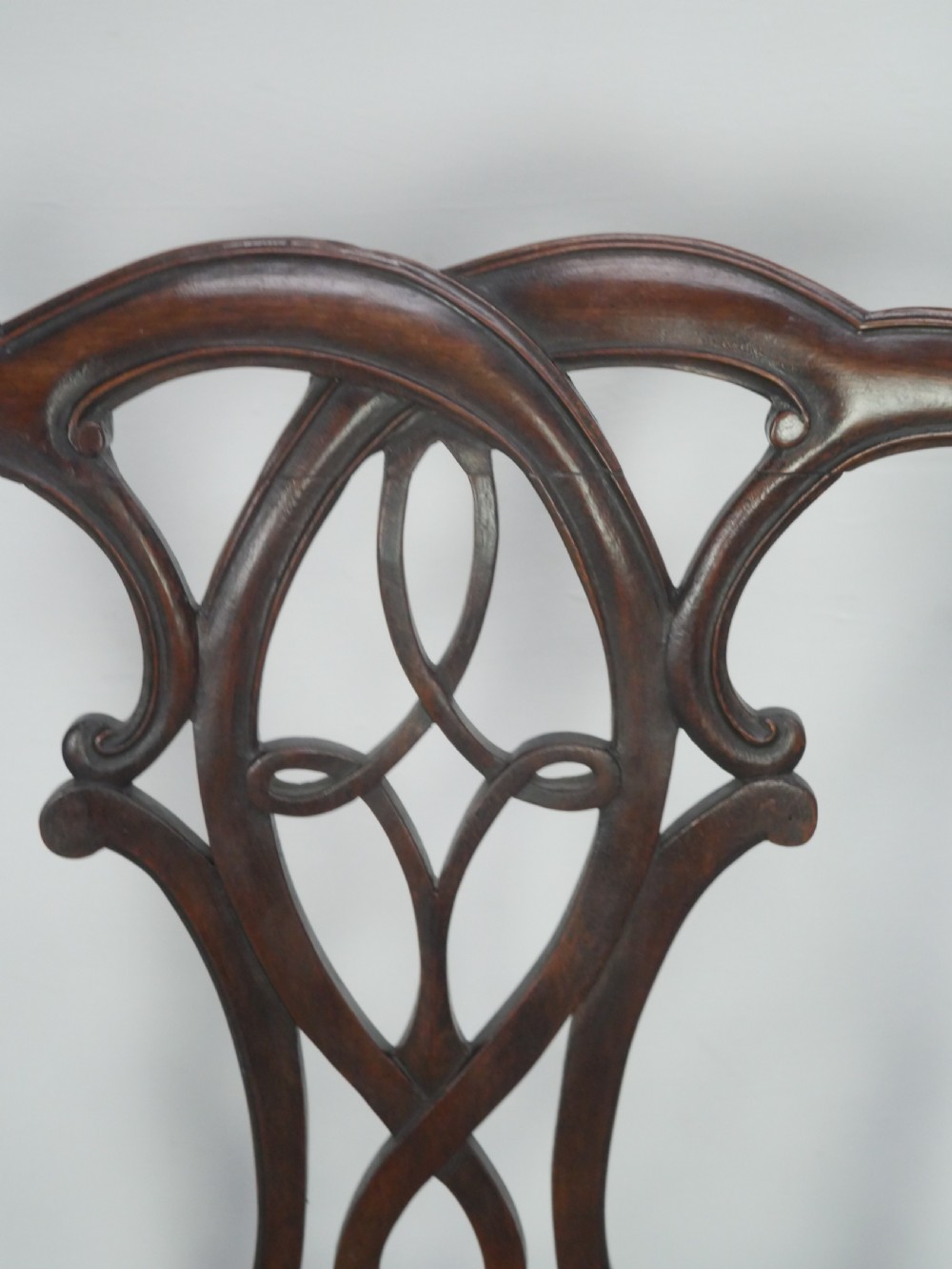 A set of eight dark mahogany Georgian style dining chairs featuring carved pierced splats and patterned fabric drop-in seats, comprising six side chairs and two carver armchairs. View VII