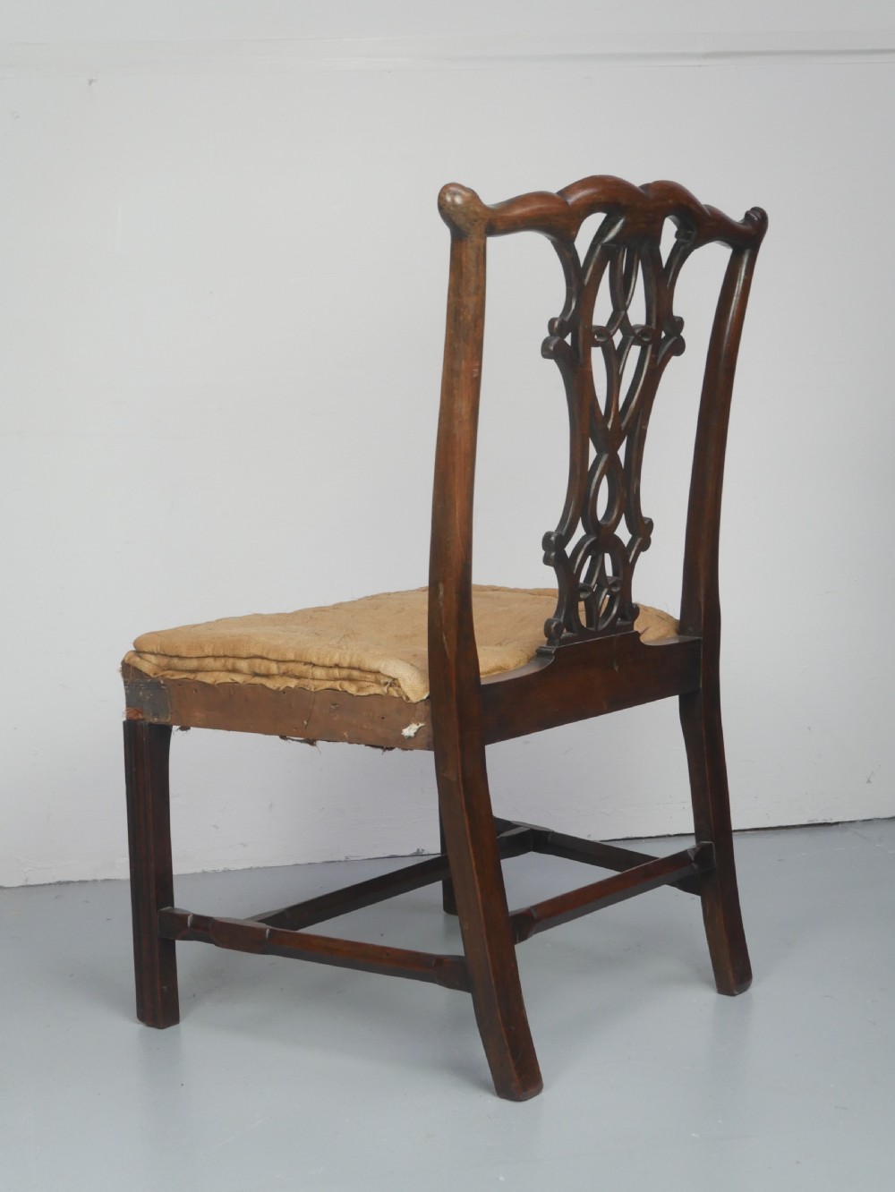 A set of eight dark mahogany Georgian style dining chairs featuring carved pierced splats and patterned fabric drop-in seats, comprising six side chairs and two carver armchairs. View X