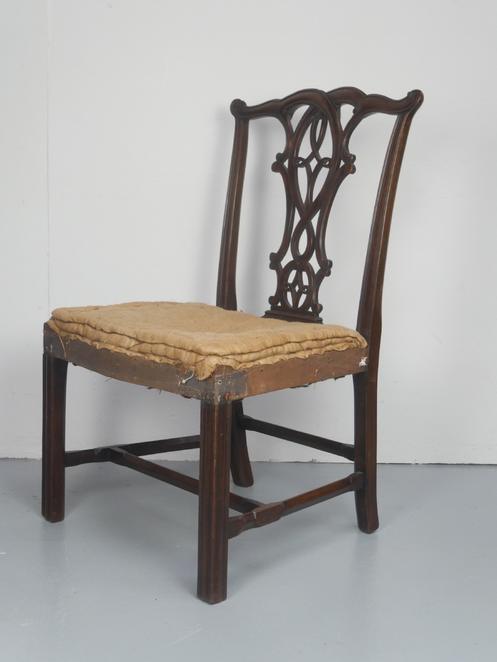 A set of eight dark mahogany Georgian style dining chairs featuring carved pierced splats and patterned fabric drop-in seats, comprising six side chairs and two carver armchairs. View XII