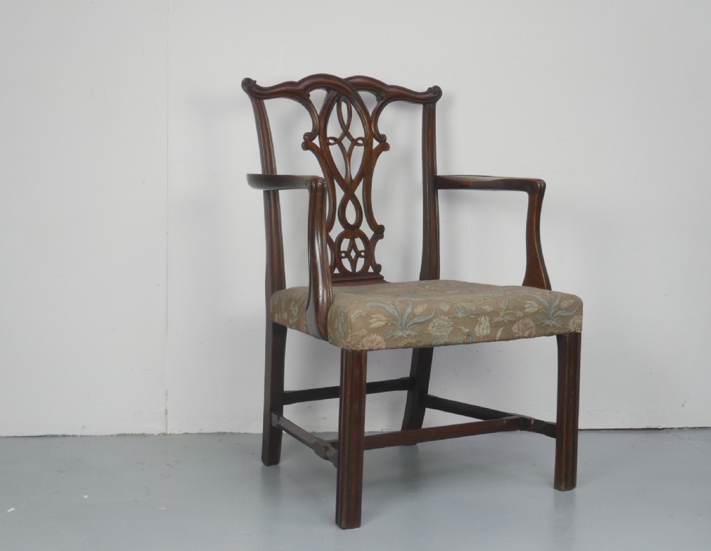 A set of eight dark mahogany Georgian style dining chairs featuring carved pierced splats and patterned fabric drop-in seats, comprising six side chairs and two carver armchairs. View XIII