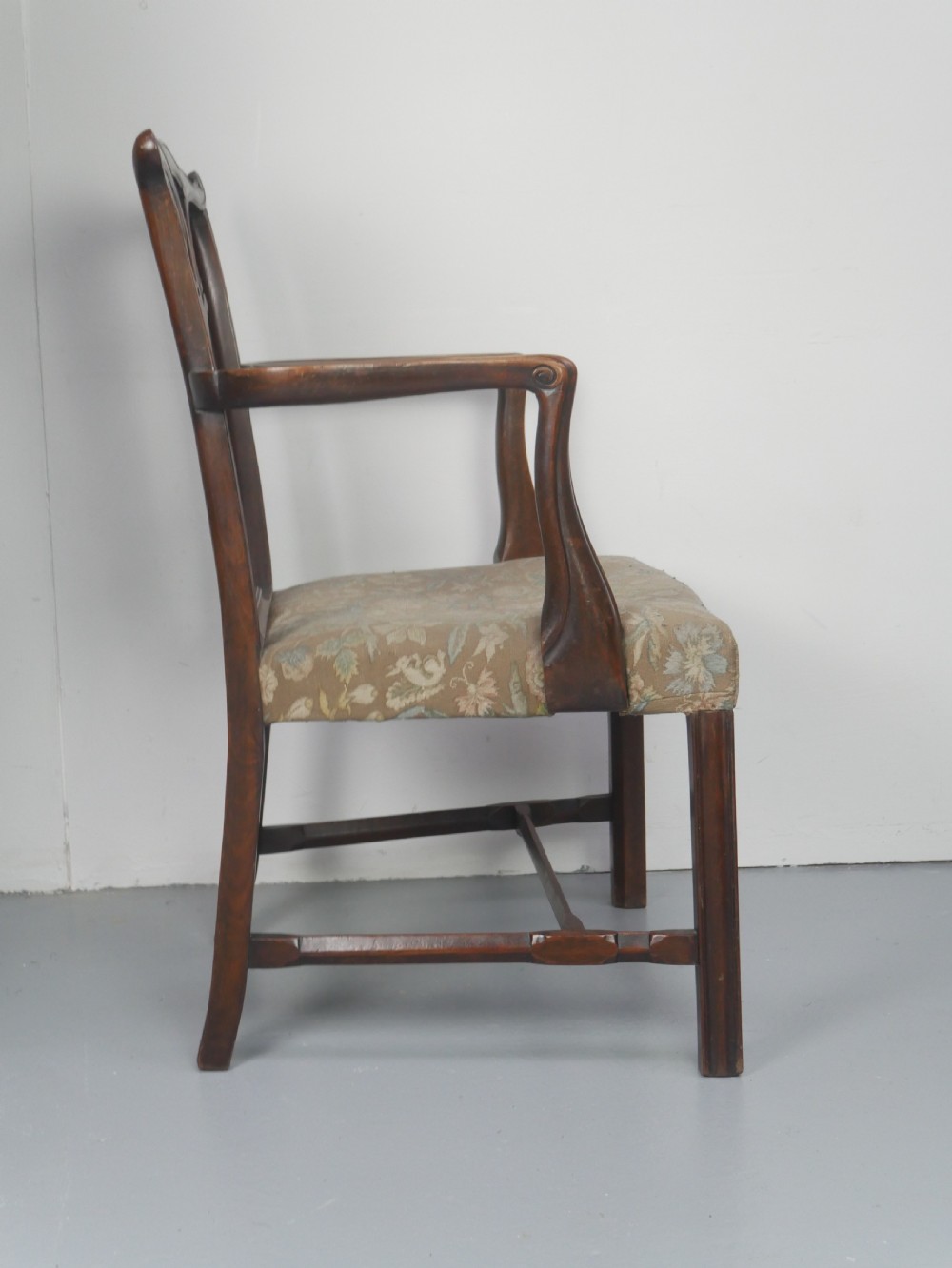 A set of eight dark mahogany Georgian style dining chairs featuring carved pierced splats and patterned fabric drop-in seats, comprising six side chairs and two carver armchairs. View XIV