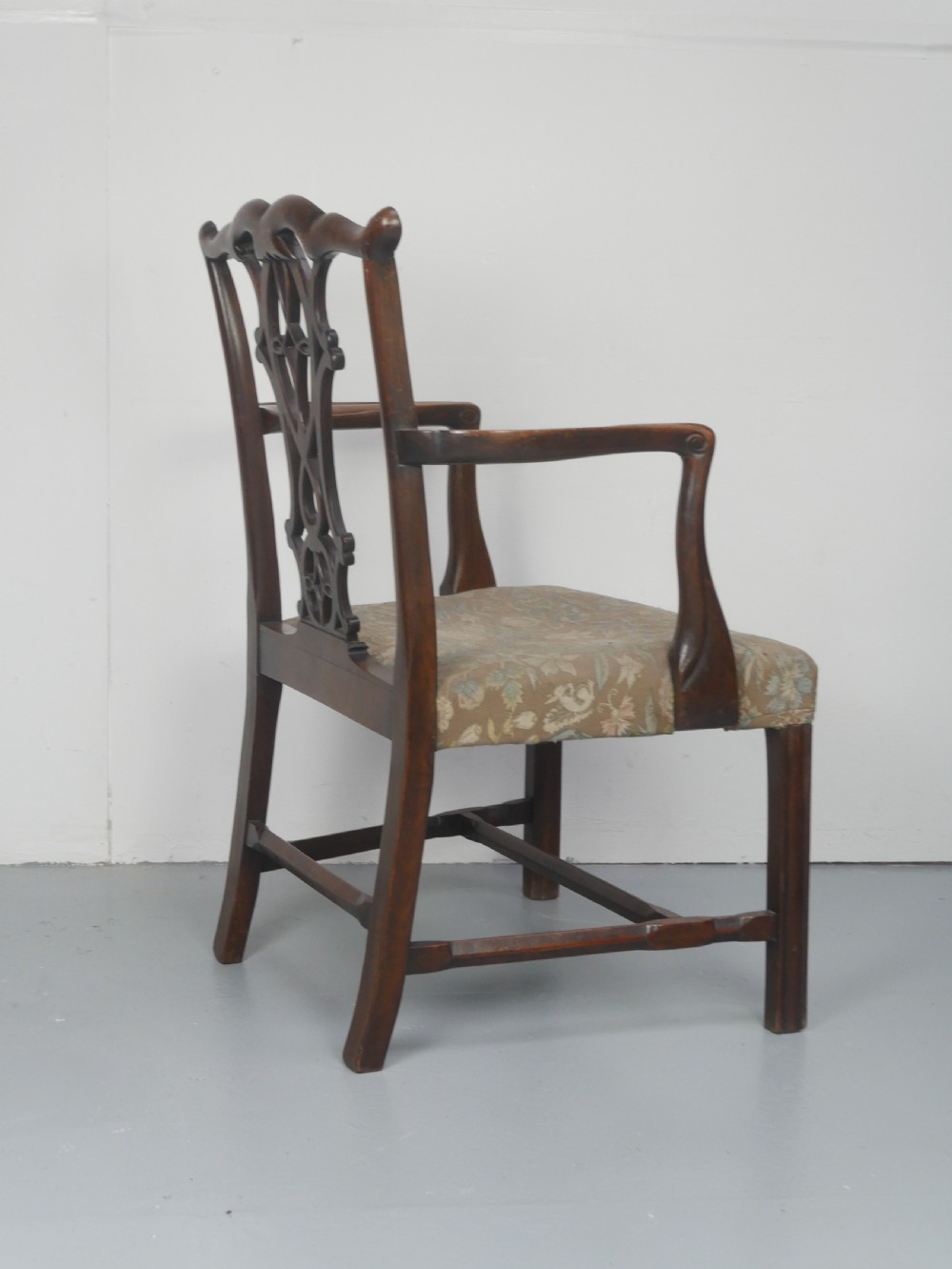 A set of eight dark mahogany Georgian style dining chairs featuring carved pierced splats and patterned fabric drop-in seats, comprising six side chairs and two carver armchairs. View XV