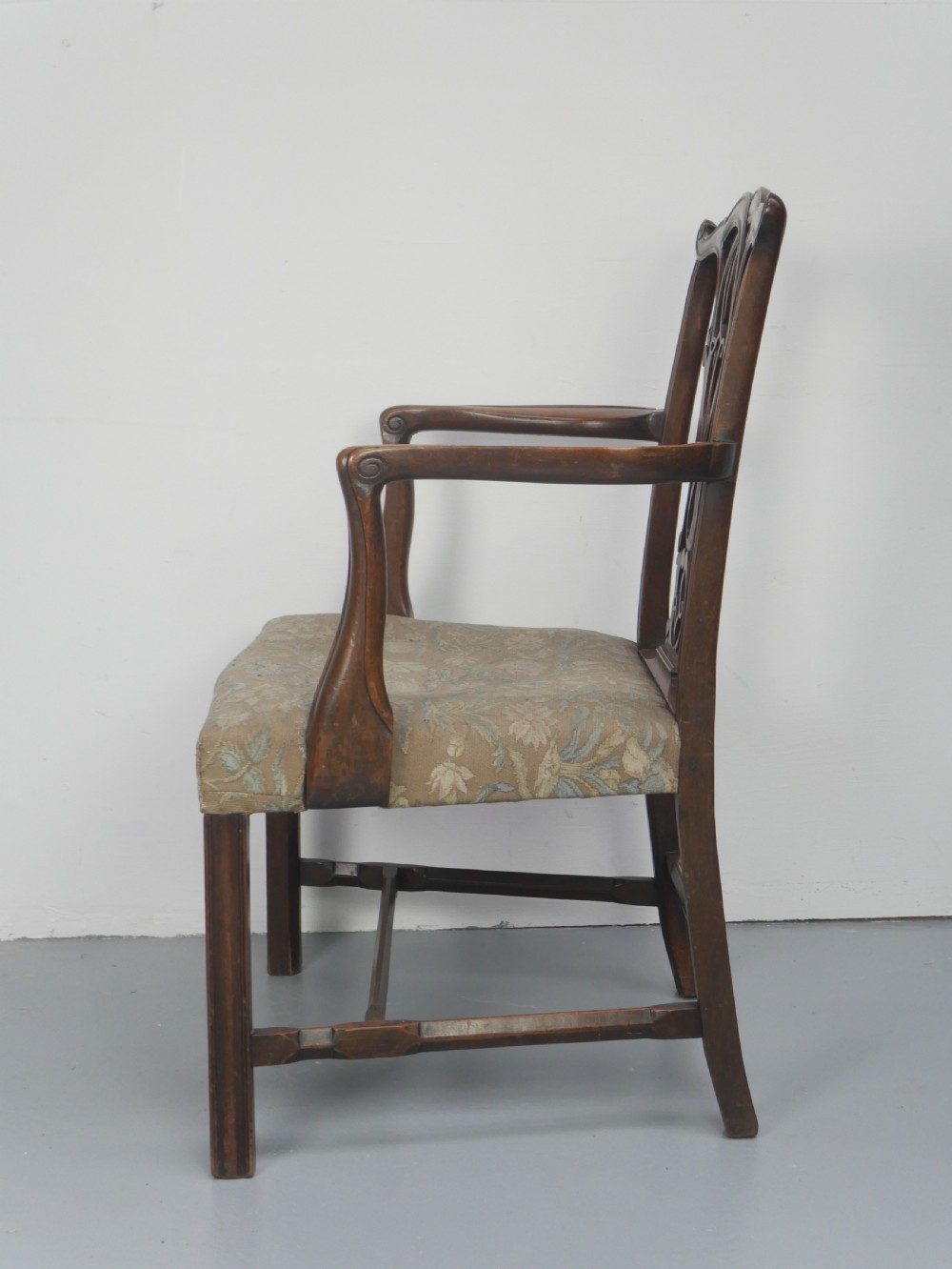 A set of eight dark mahogany Georgian style dining chairs featuring carved pierced splats and patterned fabric drop-in seats, comprising six side chairs and two carver armchairs. View XVII