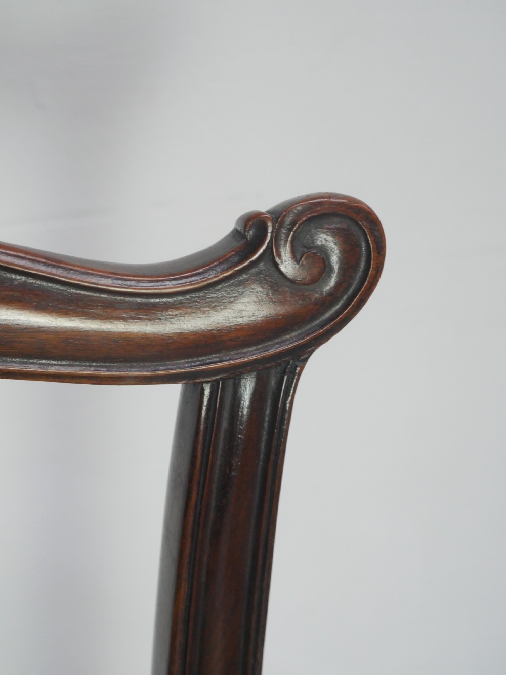 A set of eight dark mahogany Georgian style dining chairs featuring carved pierced splats and patterned fabric drop-in seats, comprising six side chairs and two carver armchairs. View XVIII
