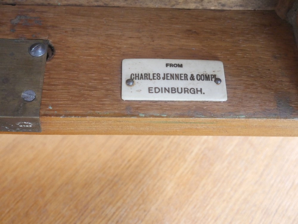 A golden oak writing table with two frieze drawers fitted with brass drop handles, raised on four square tapered legs. View VIII