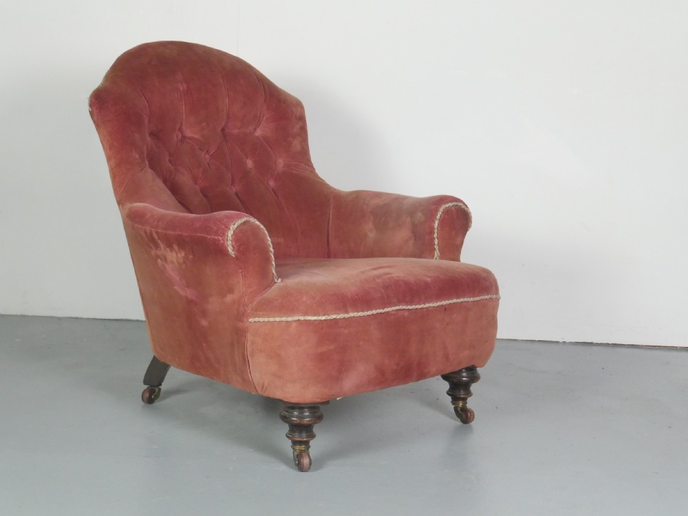 A Victorian button-back armchair upholstered in dusty pink velvet, featuring turned front wooden legs set on brass castors. View IX