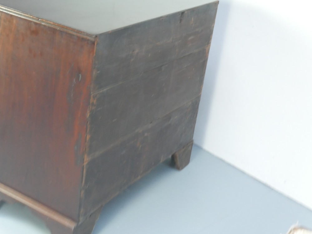 A Georgian mahogany chest of drawers featuring two short over two long graduated drawers with round brass handles and bracket feet. View IV