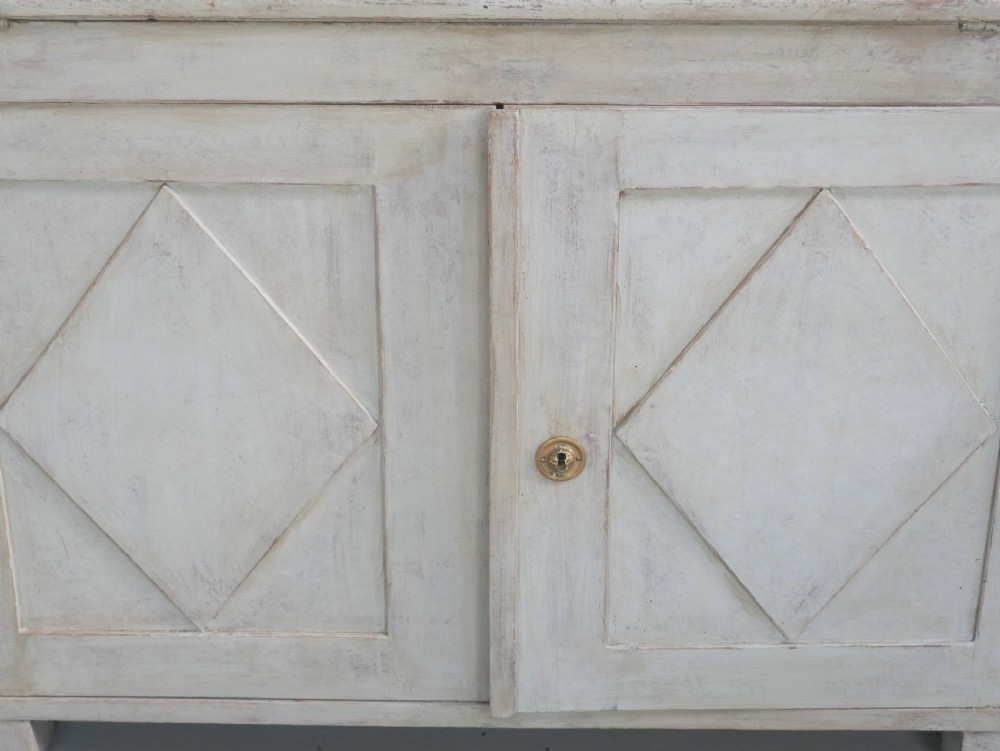 A tall two-tier Swedish softwood bureau cabinet with diamond panel moulding on the doors, a slanted fall-front flap, and a distressed pale grey painted finish. View IX