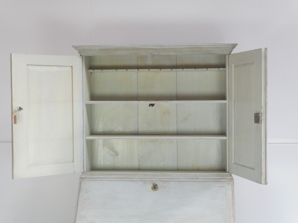 A tall two-tier Swedish softwood bureau cabinet with diamond panel moulding on the doors, a slanted fall-front flap, and a distressed pale grey painted finish. View XX