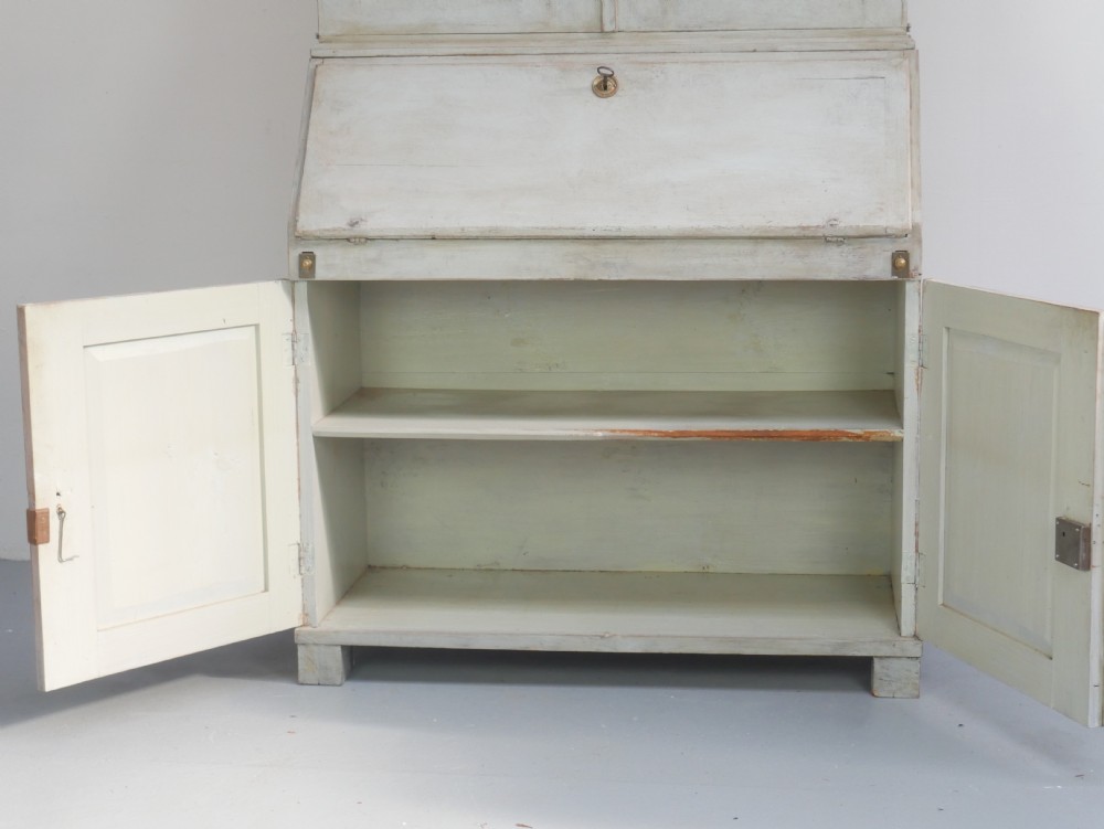A tall two-tier Swedish softwood bureau cabinet with diamond panel moulding on the doors, a slanted fall-front flap, and a distressed pale grey painted finish. View III