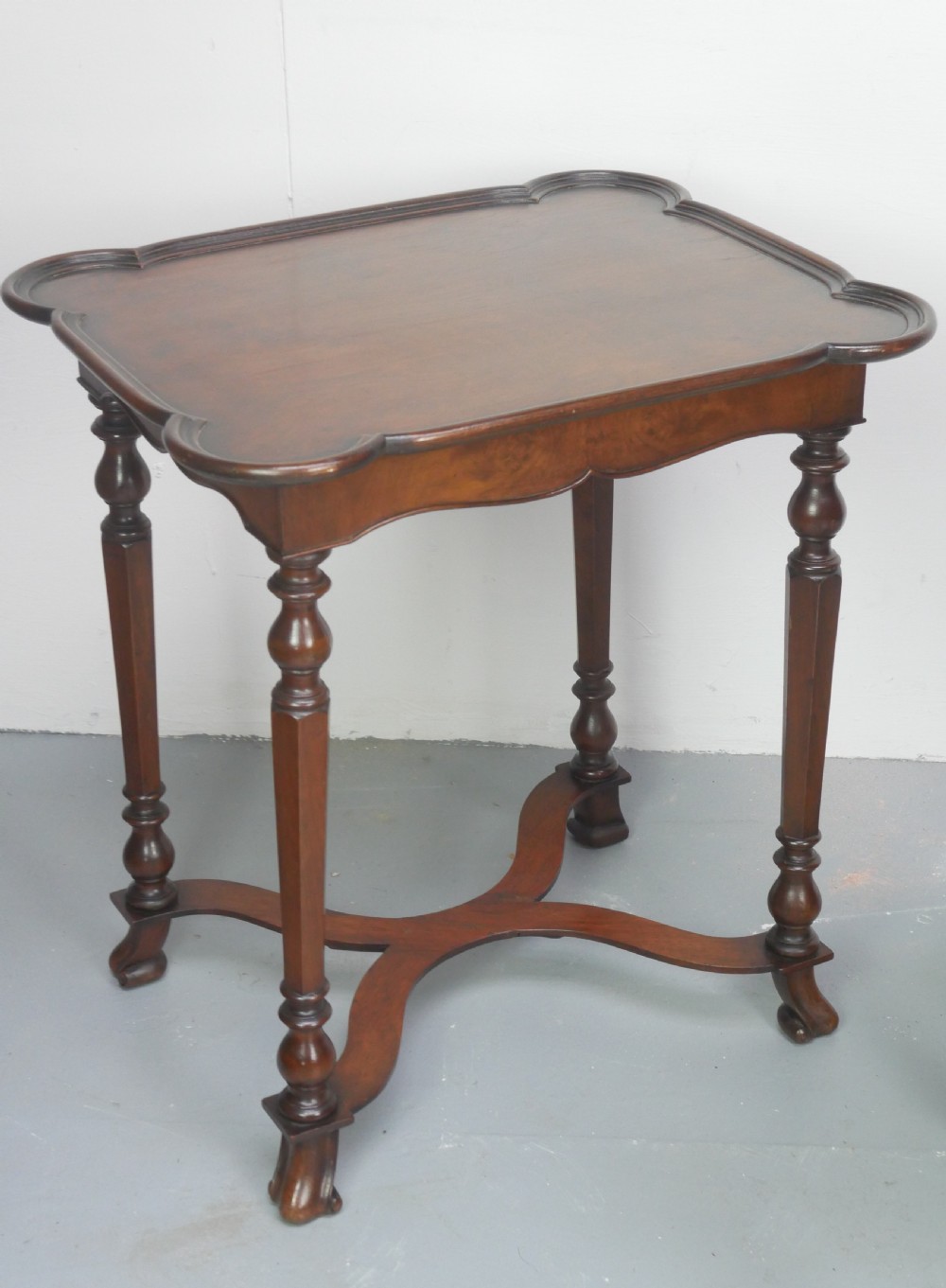 A matching pair of polished warm brown mahogany side tables featuring raised tray-top edges, turned legs, and curved X-stretchers. View II