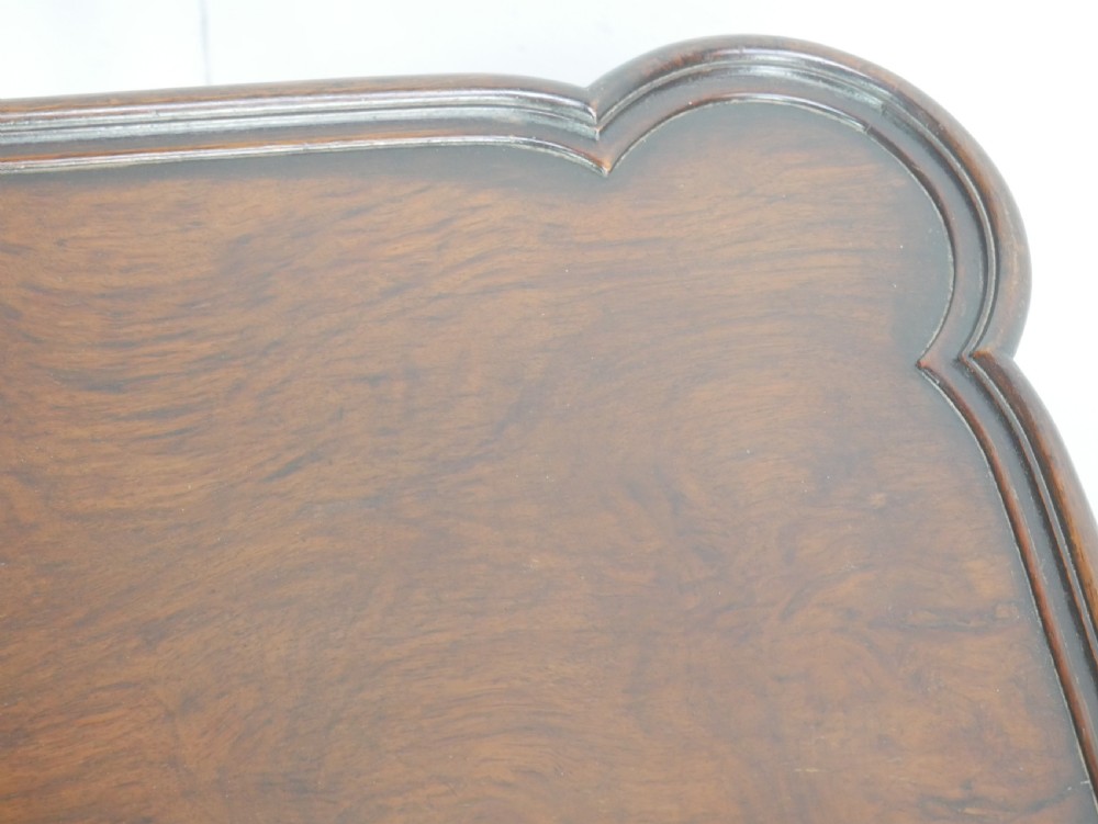 A matching pair of polished warm brown mahogany side tables featuring raised tray-top edges, turned legs, and curved X-stretchers. View VI