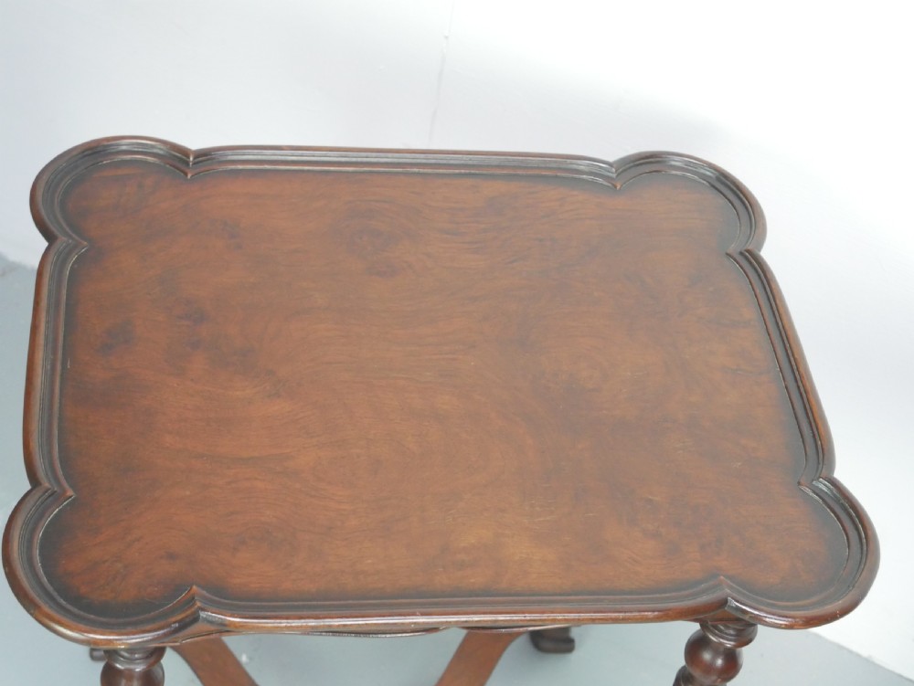 A matching pair of polished warm brown mahogany side tables featuring raised tray-top edges, turned legs, and curved X-stretchers. View XI